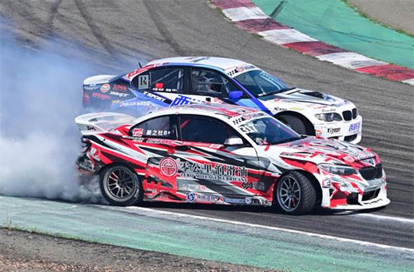 Race cars on a track with smoke coming out of them Description automatically generated